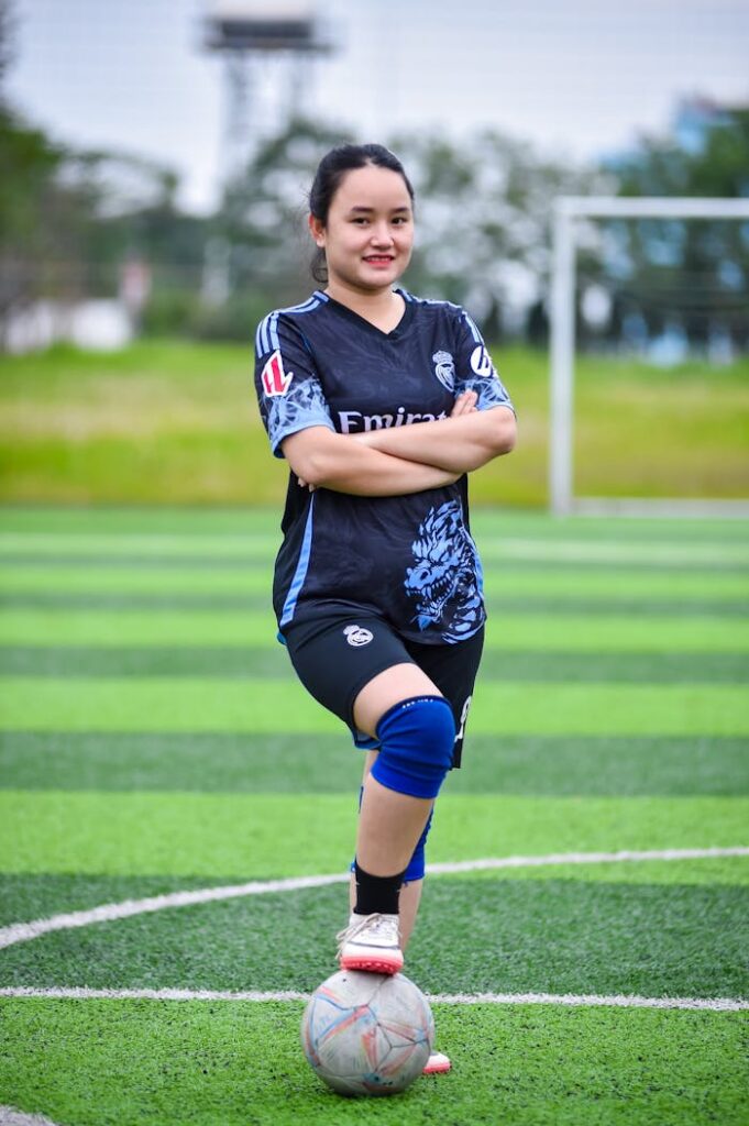 A young woman poses confidently on a soccer field in Hanoi, capturing team spirit and athleticism.